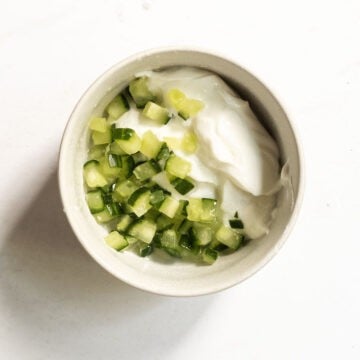 Simple tzatziki ingredients mixed together in a bowl.