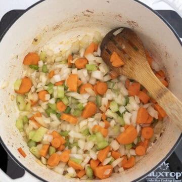 Sauteing the celery, onions, and carrots in a dutch oven.