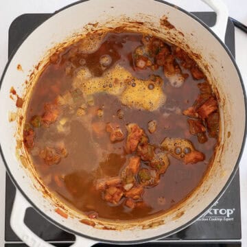 Pumpkin beer and chicken broth added to dutch oven.