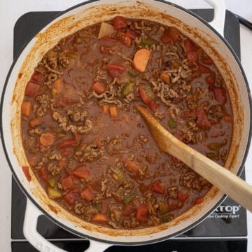 Diced tomatoes with chilis and ground beef added to the dutch oven.