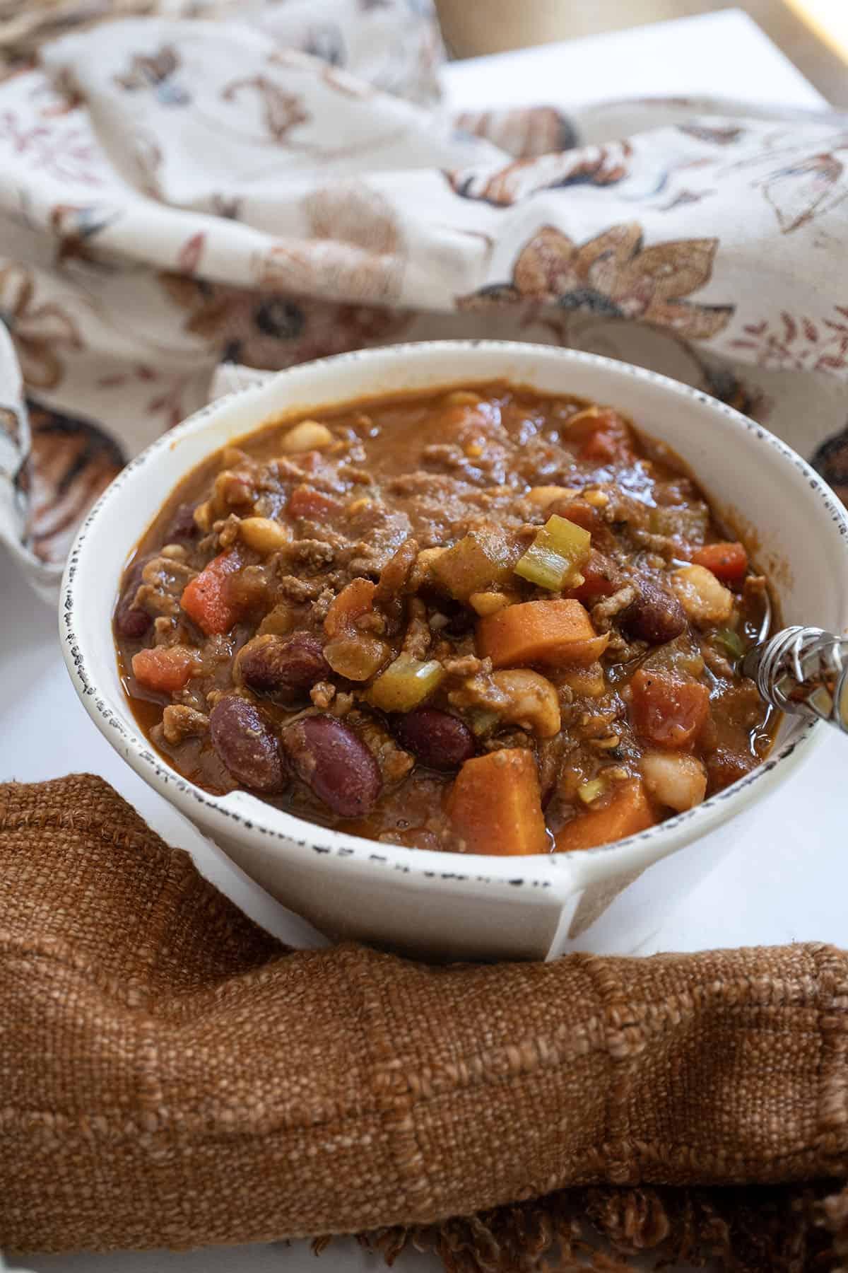 Bowl of pumpkin chili with a spoon. 