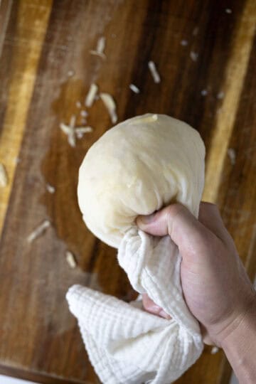 Drying grated potatoes with a cheese cloth.