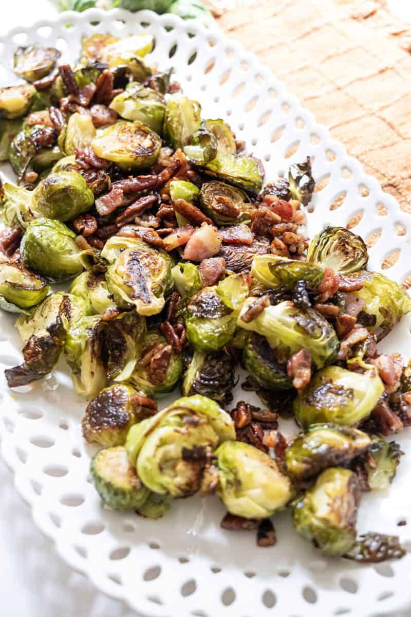 Roasted Brussels sprouts on a plate with bacon and pecans.