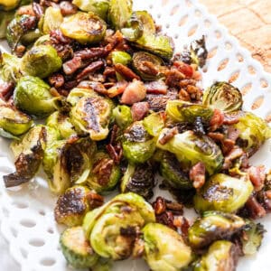 Brussels sprouts plated with bacon and pecans drizzled with maple syrup.