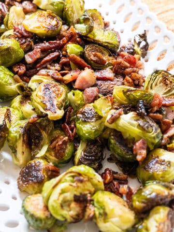 Brussels sprouts plated with bacon and pecans drizzled with maple syrup.