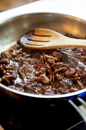 Sugar caramelizing to the pecans in the saucepan. 