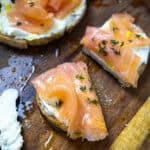 Lox on top of mascarpone toast on a cutting board with an old school butter knife covered in mascarpone.