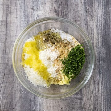 Breadcrumbs, parmesan, parsley, salt, pepper, lemon juice, and minced garlic combined in a bowl.