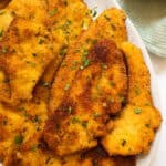 Italian chicken cutlets on piled on a plate.