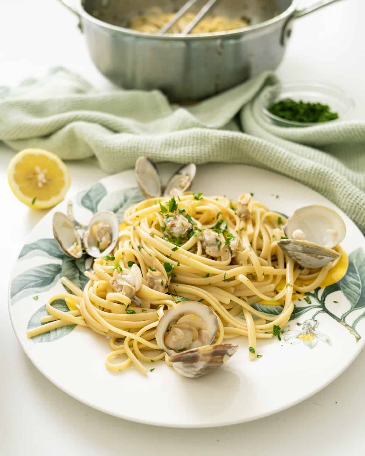 Linguine with clams served on a plate with an extra lemon.