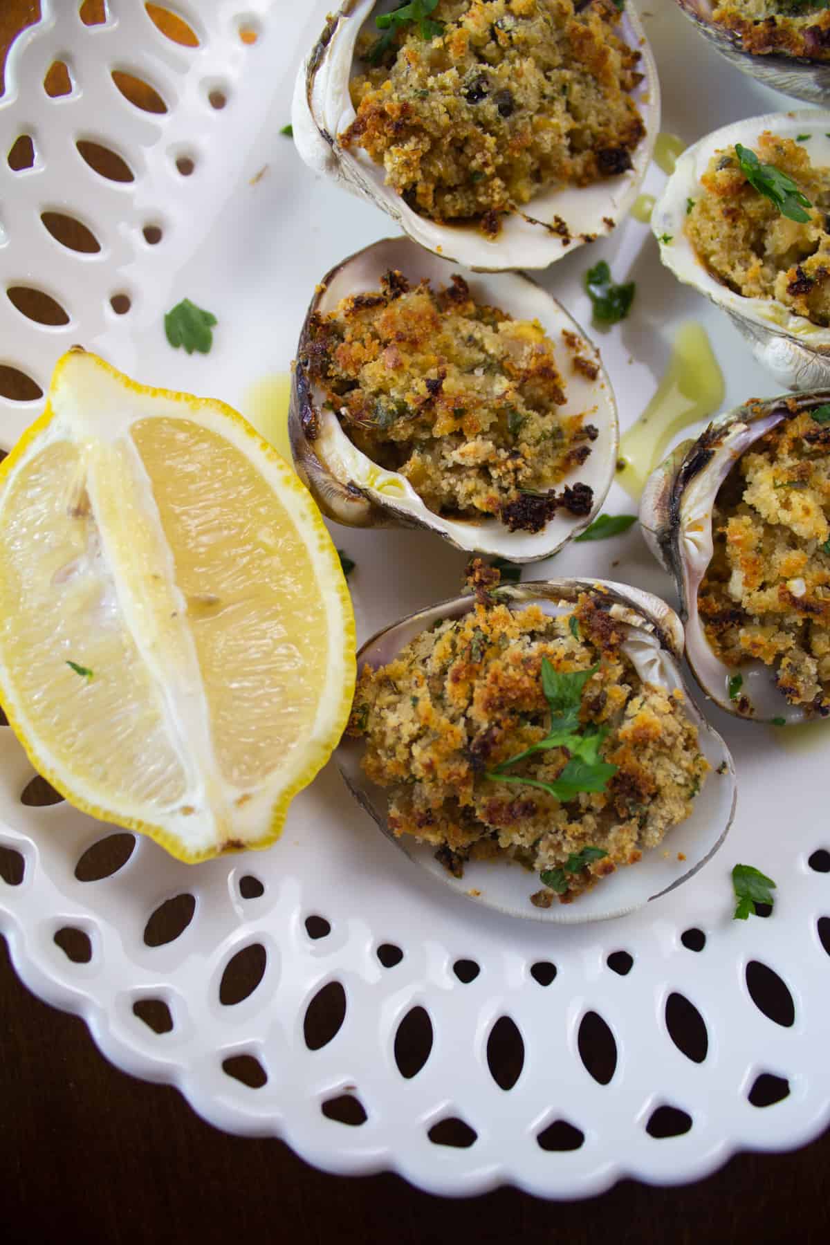 close up of baked clams garnished with parsley and lemon