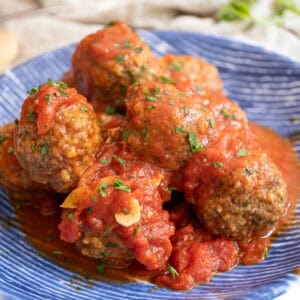 Meatballs covered in tomato sauce in a bowl.