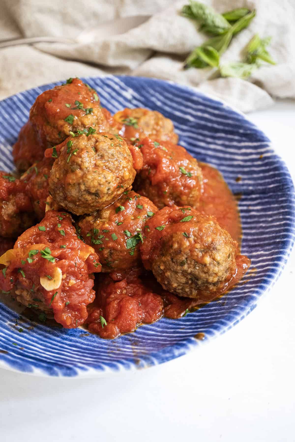 Meatballs covered in tomato sauce in a bowl. 