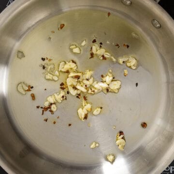 Garlic and crushed red pepper sauteing in a pan. 