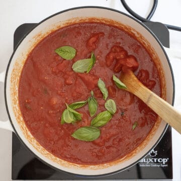 Tomatoes and basil added to the pot.