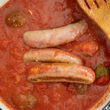 Sauce simmering with sausage and meatballs.