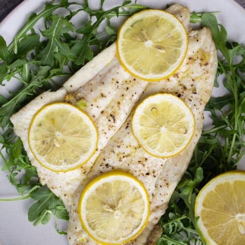 broiled lemon over arugula topped with lemon slices and seasoned with salt and pepper
