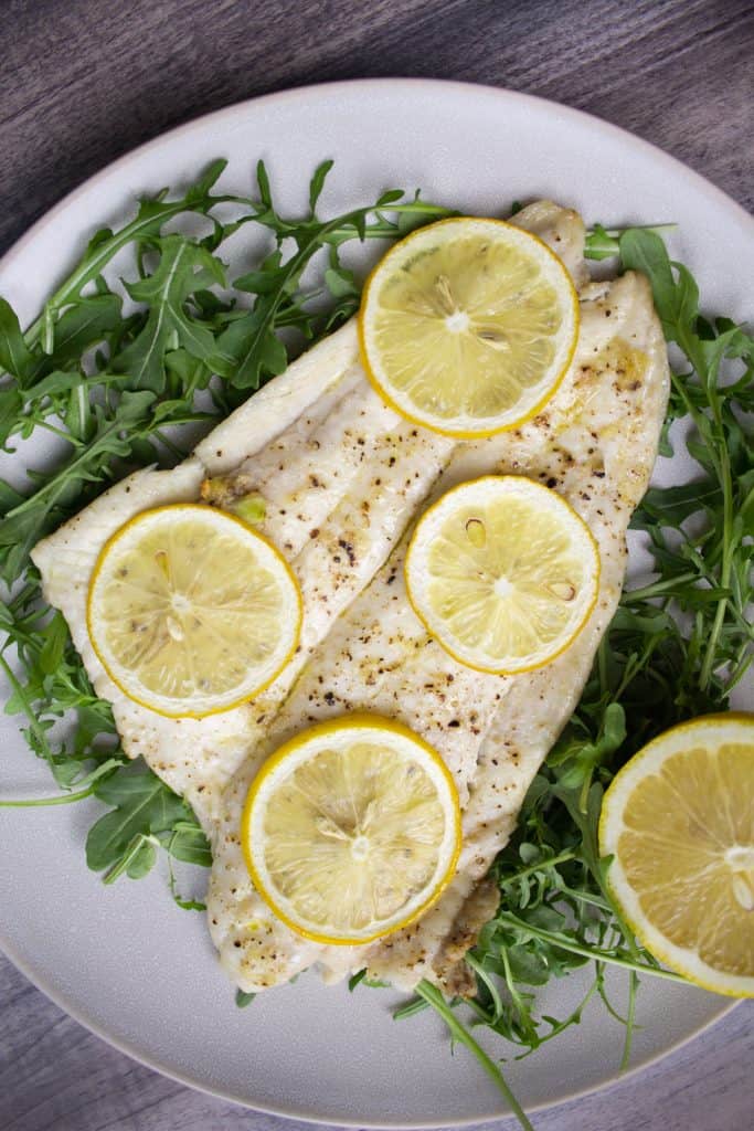 broiled lemon over arugula topped with lemon slices and seasoned with salt and pepper