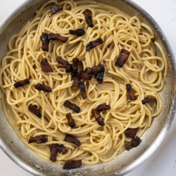 Guanciale returned to the pan with the pasta.