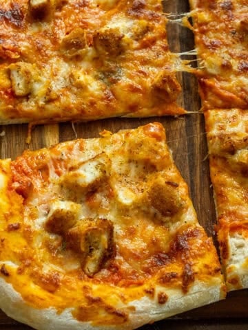 Pizza cut into slices on the cutting board.