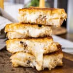 4 halves of the grilled cheese stacked on top of one another.