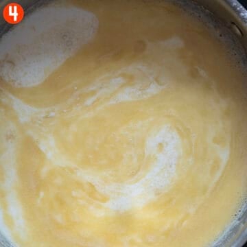Combining whole milk and roux in the pan.