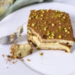 Pistachio Cream tiramisu on a plate with a forkful scooped out.