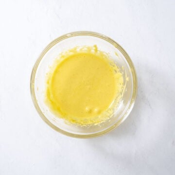 Egg yolks and sugar combined in a bowl.