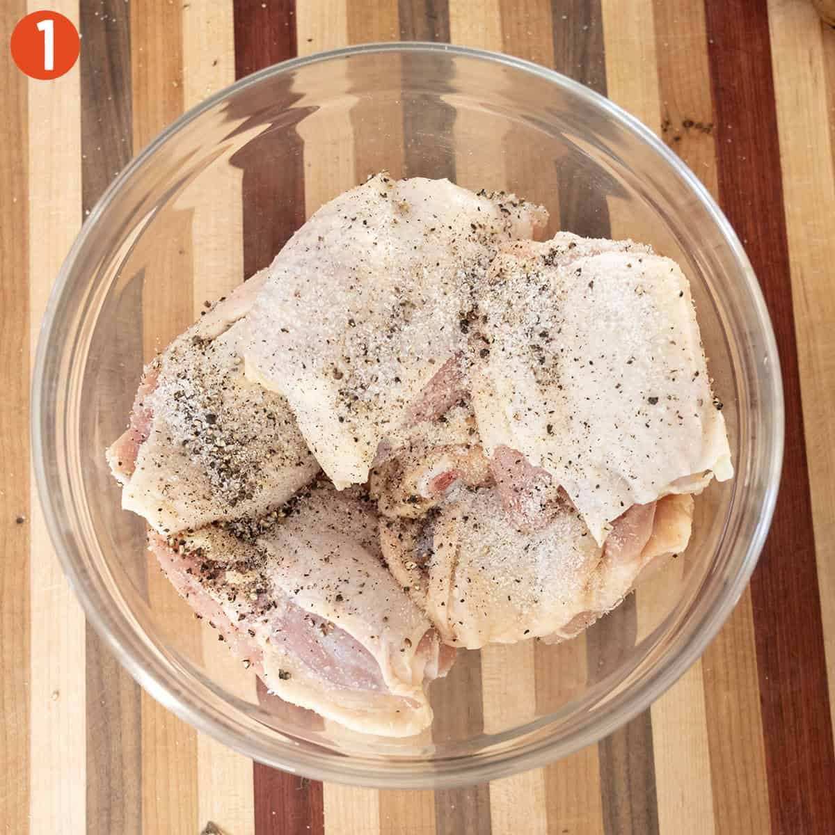 Seasoned chicken thighs in a bowl.