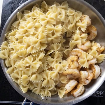 Pasta and shrimp combined in the pan.