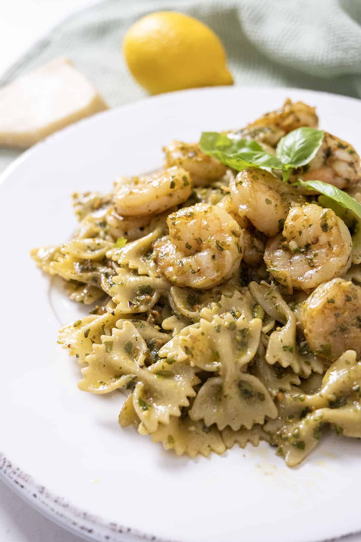 Shrimp over pesto pasta garnished with basil.