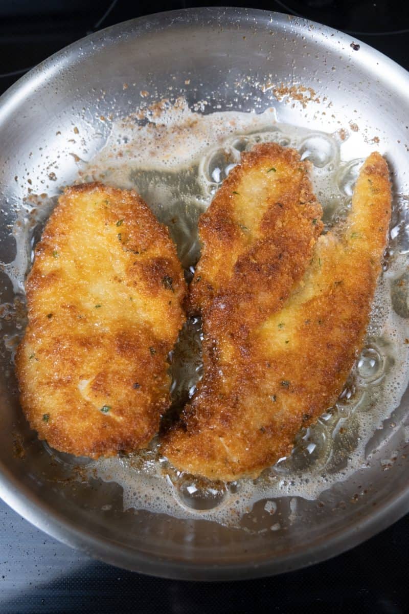 chicken cutlets frying in canola oil