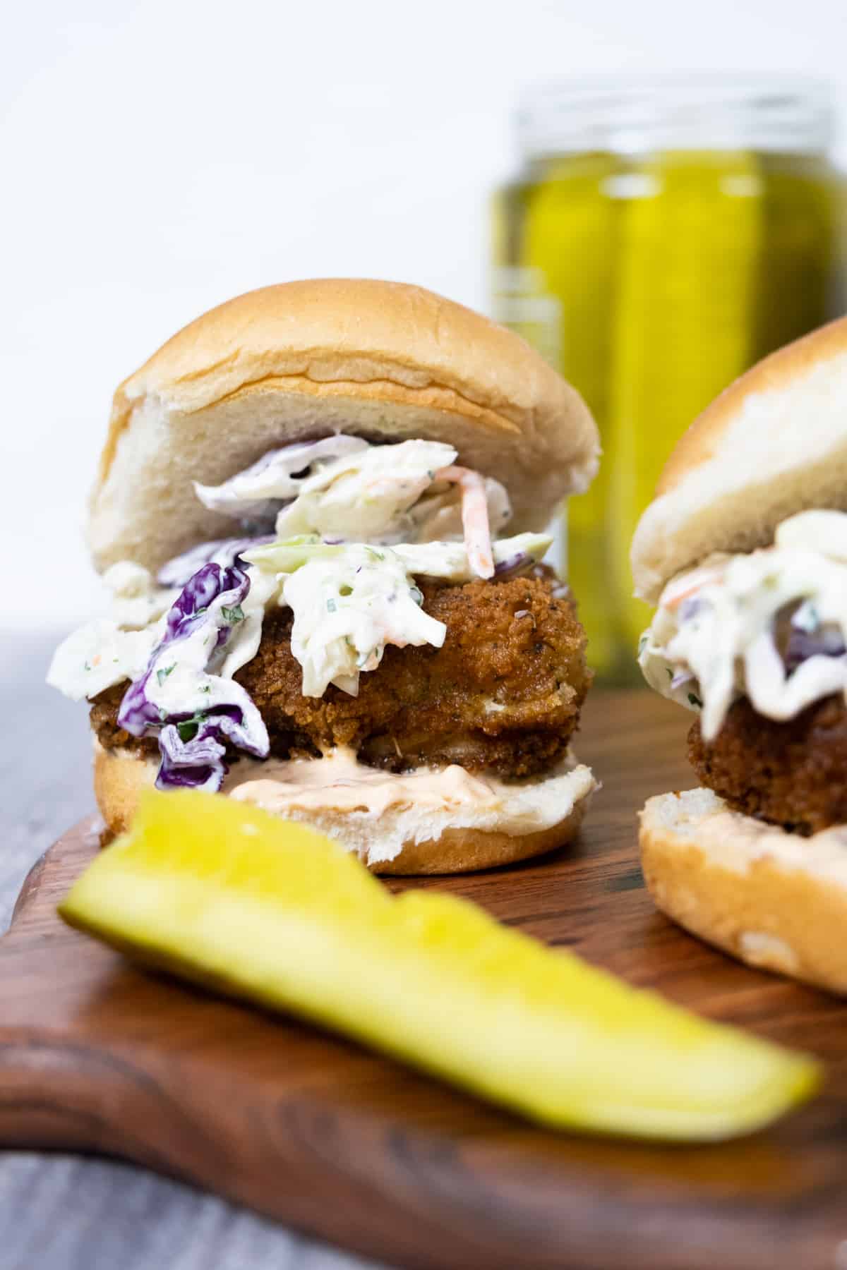 Crispy fish slider with coleslaw and chipotle mayo. Side of pickle