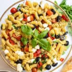 Italian pasta salad in large bowl garnished with basil.