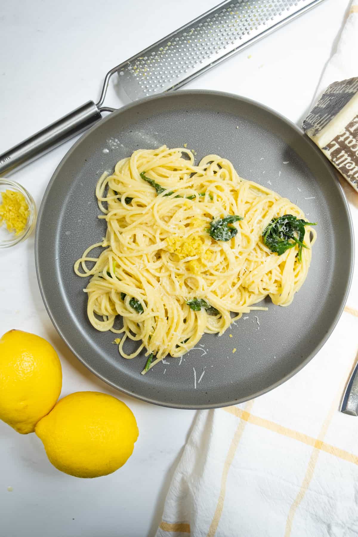 lemon spinach pasta with lemons, zest and pecorino on side