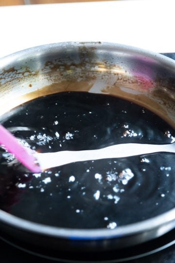 balsamic glaze thickening with lazy trail left behind after spatula dragged through