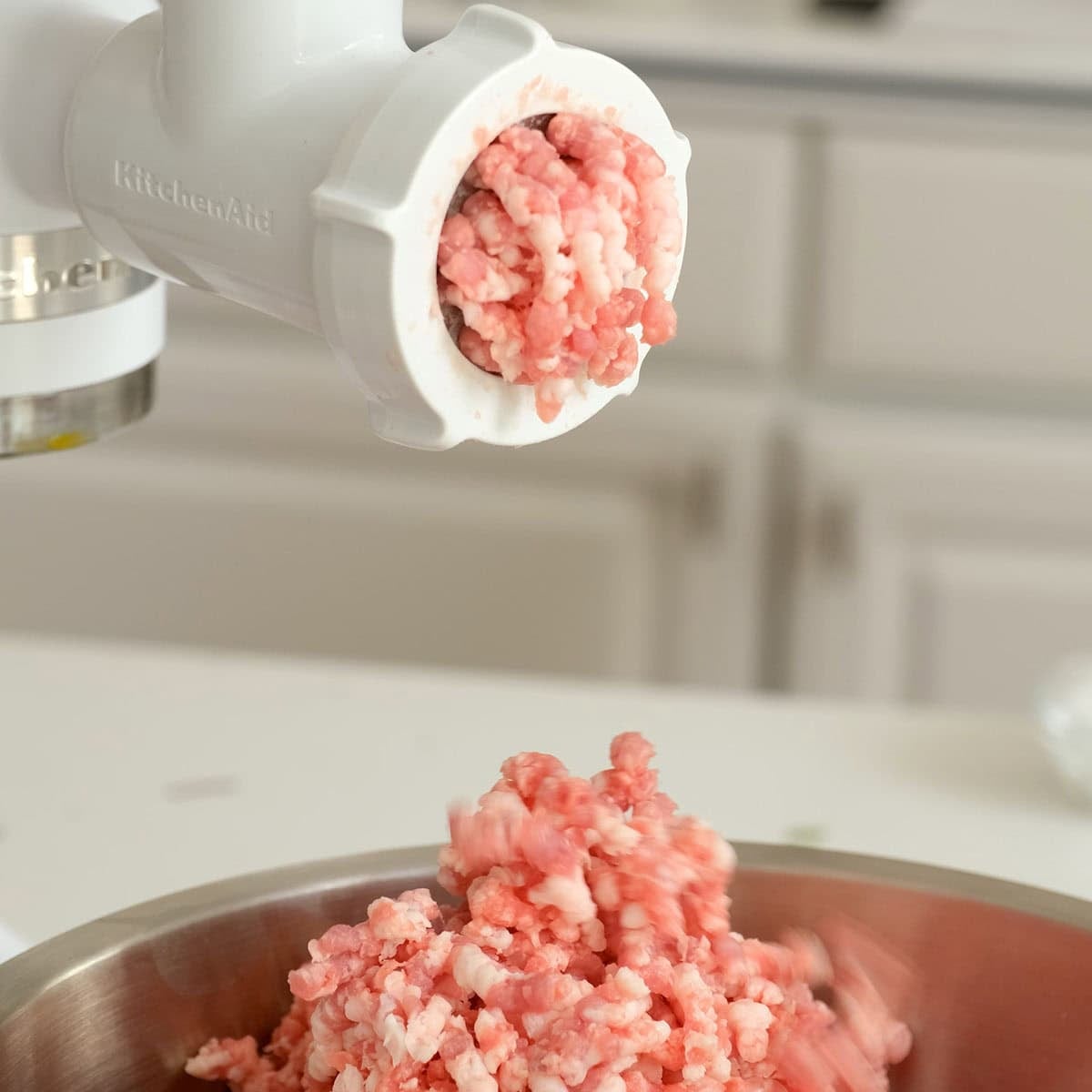 Grinding pork in a meat grinder.