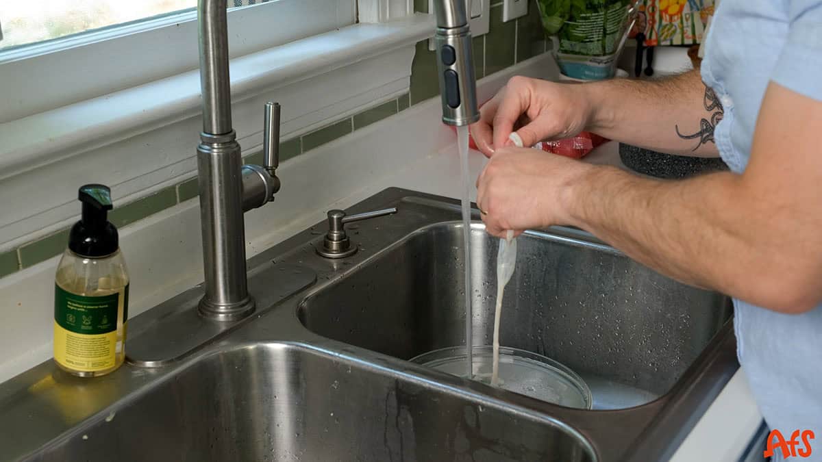 Vinny rinsing the casing in the sink.