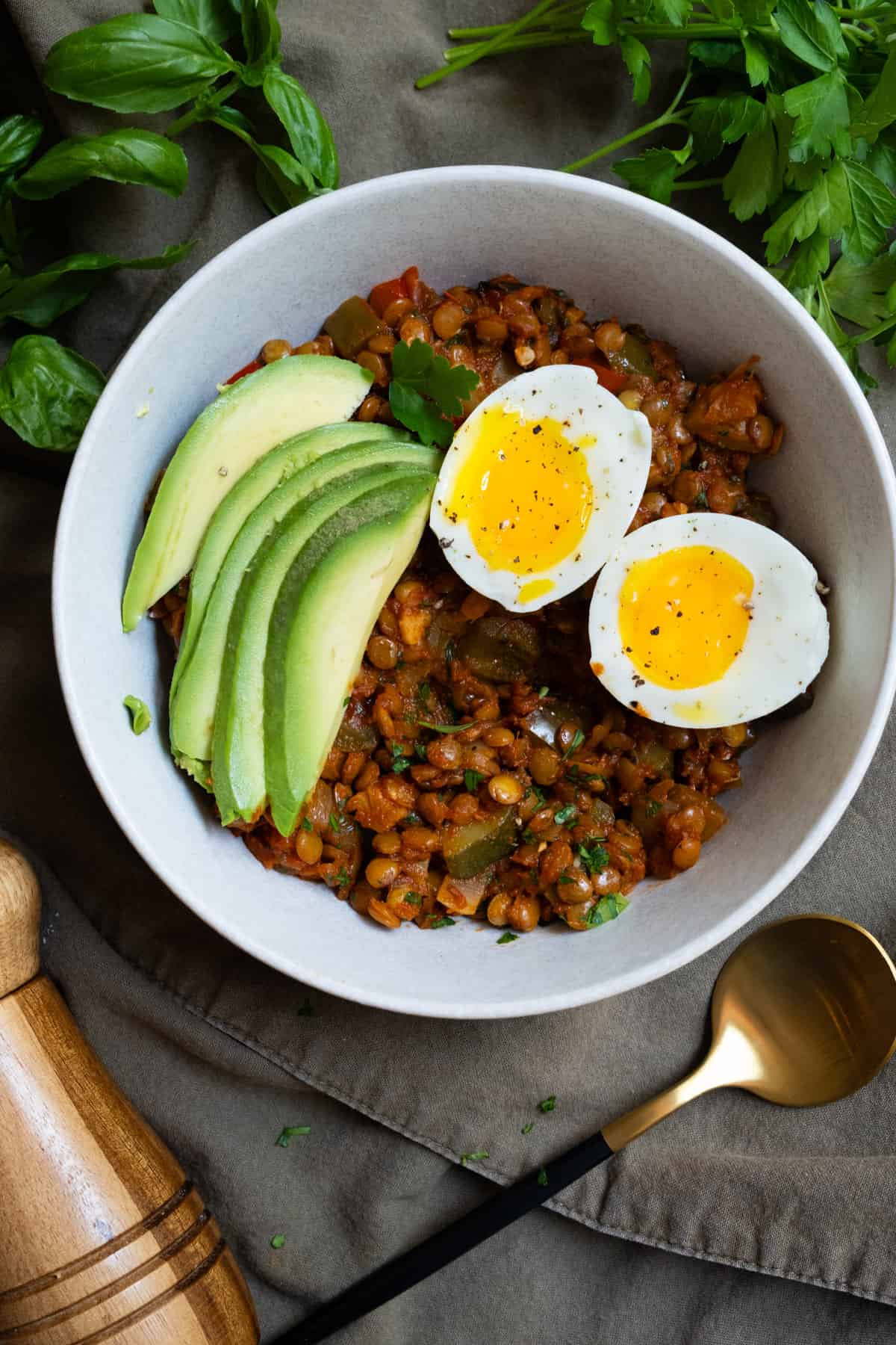 soft boiled Eggs and Lentils in tomato sauce for breakfast with sliced avocado