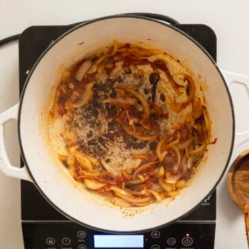 Caramelizing tomato paste with onions.