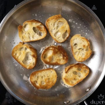 Bread being toasted in frying pan.