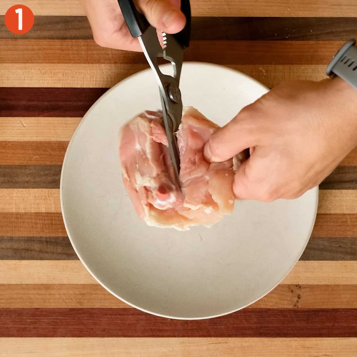 Preparing chicken thighs with seasoning and splitting in half.