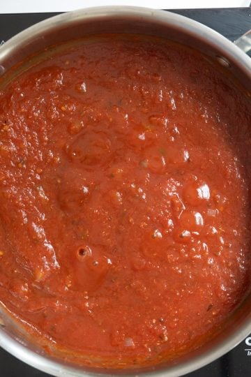 Sauce beginning to simmer in a pan.
