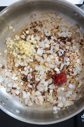 Garlic and tomato paste added to shallots.