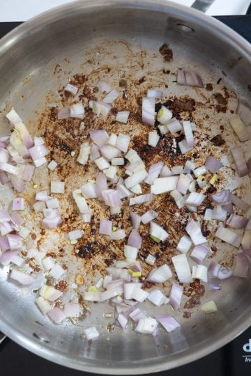 Shallots sauteing in a pan.