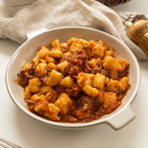 Braised Italian short ribs served over homemade gnocchi in a bowl.