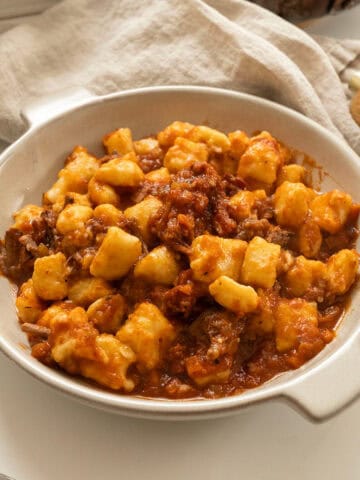 Braised Italian short ribs served over homemade gnocchi in a bowl.