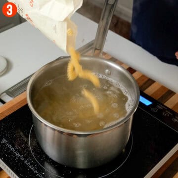 Boiling pasta in water.