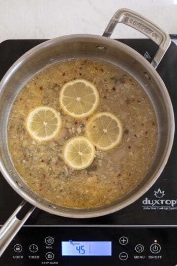 white wine simmering with lemons and capers