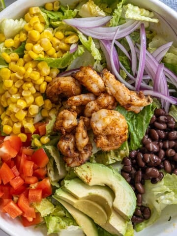 grilled shrimp salad with beans, red pepper, corn, red onion, beans, and avocado